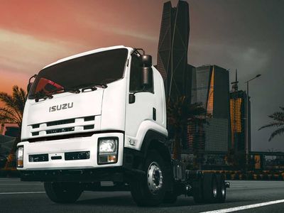 An Isuzu truck on the highway at dusk